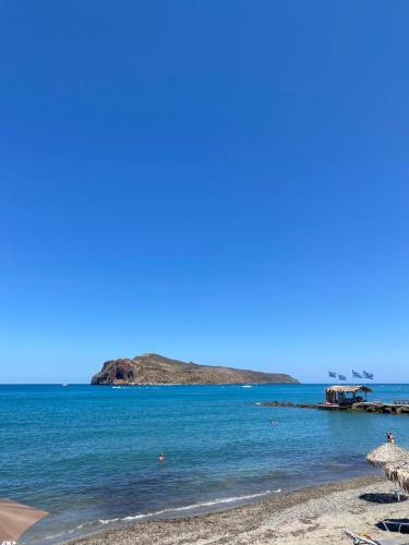 a beach with an island in the water at Tile apartments #1 in Agia Marina Nea Kydonias