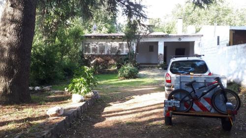 a bike in the back of a car parked in a yard at Casa en el Río in Alpa Corral