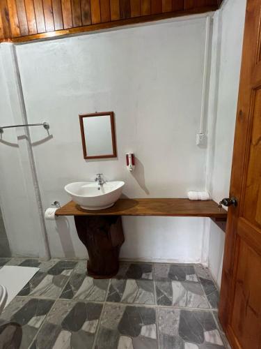 a bathroom with a sink and a mirror at Arenal Rústic Lodge in Fortuna