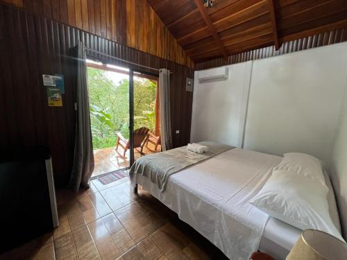 a bedroom with a bed and a sliding glass door at Arenal Rústic Lodge in Fortuna