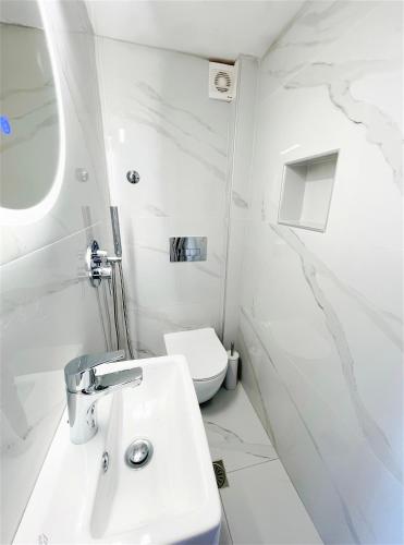 a white bathroom with a sink and a toilet at The Little Prince in Petra
