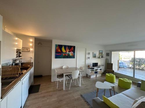 une cuisine et un salon avec une table et des chaises dans l'établissement Appartement 3 pièces avec jardinet, 6 personnes, internet, proche Grand Hôtel de Cabourg - FR-1-487-308, à Cabourg