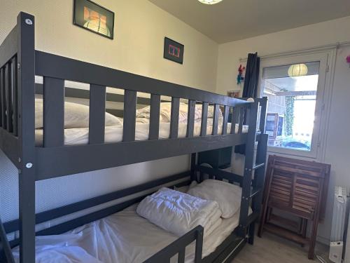 - un lit superposé noir avec un oreiller blanc dans l'établissement Appartement 3 pièces avec jardinet, 6 personnes, internet, proche Grand Hôtel de Cabourg - FR-1-487-308, à Cabourg