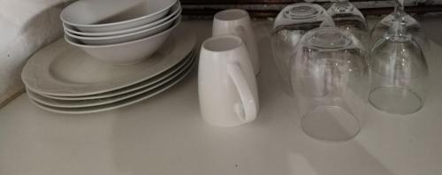 a counter with plates and utensils and cups and dishes at 260 Jozi Maboneng - Uncapped Wi-Fi in Johannesburg