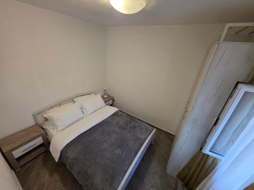 a small bedroom with a bed and a window at Apartmani Komatina Đenovići 2 in Herceg-Novi