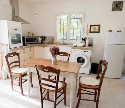 Il comprend une cuisine équipée d'une table et de chaises. dans l'établissement Location maison LORGUES 