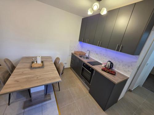a kitchen with a table and a sink and a counter at Apartmani Komatina Đenovići 2 in Herceg-Novi