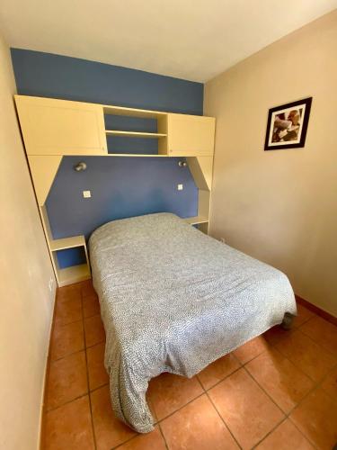 une chambre avec un lit avec une tête de lit bleue dans l'établissement AGREABLE T2 LISIERE DU GOLF LACANAU OCEAN, à Lacanau-Océan