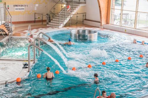 grupa ludzi bawiących się w krytym basenie w obiekcie Hotel i Aquapark Olender w Toruniu