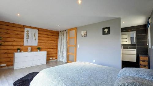 Cet appartement comprend une chambre avec un lit blanc et une cuisine. dans l'établissement Chalet bois, à Kervic