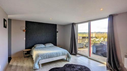 une chambre avec un lit et une grande fenêtre dans l'établissement Chalet bois, à Kervic