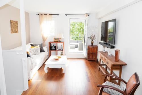 un salon avec un canapé blanc et une table dans l'établissement Maison familiale située à 20 mn de Paris et Disneyland, à Noisy-le-Grand