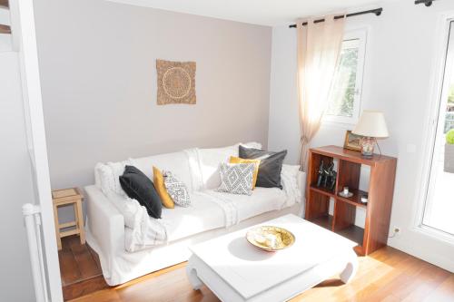 un salon avec un canapé blanc et une table dans l'établissement Maison familiale située à 20 mn de Paris et Disneyland, à Noisy-le-Grand