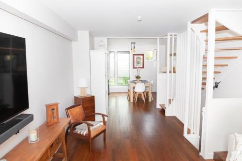 un salon avec une télévision et une table dans l'établissement Maison familiale située à 20 mn de Paris et Disneyland, à Noisy-le-Grand