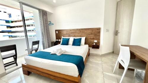 a hotel room with a bed and a table and chairs at Hotel Chayrama in Santa Marta