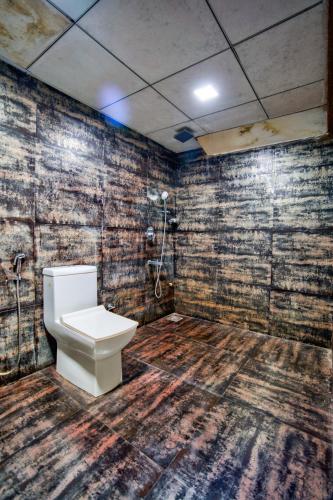 a bathroom with a toilet and a wooden floor at Luxury Aveeno Resort Near Calangute and Baga in Sangolda