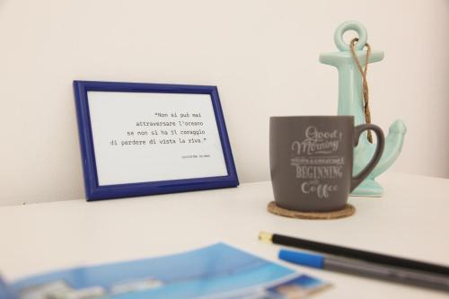 a framed picture and a coffee mug on a desk at Rest House The Village in Nardò