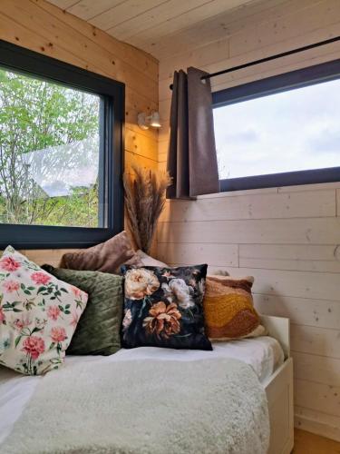 - une chambre avec deux fenêtres et un lit avec des oreillers dans l'établissement My Tiny House proche mer, à Clohars-Fouesnant