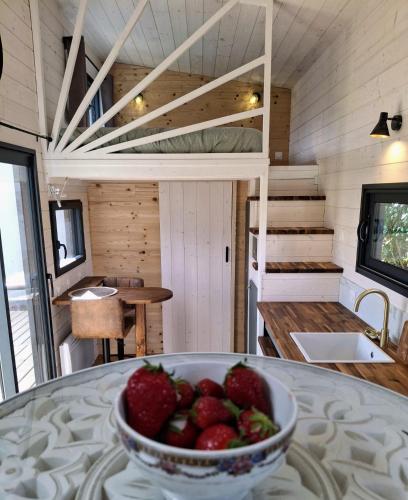 un bol de fraises sur une table dans une petite maison dans l'établissement My Tiny House proche mer, à Clohars-Fouesnant