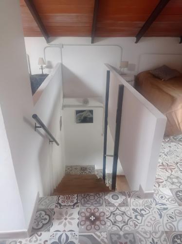 a white room with a staircase and a bed at Finca Rústica La Pájara in Villanueva del Arzobispo