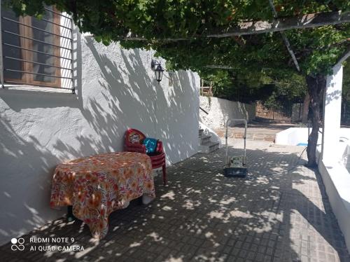 a table and a chair sitting next to a wall at Finca Rústica La Pájara in Villanueva del Arzobispo
