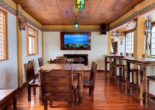 a dining room with tables and a tv on the wall at Quinta maría isabel. Elegante y restaurada in Gualaceo