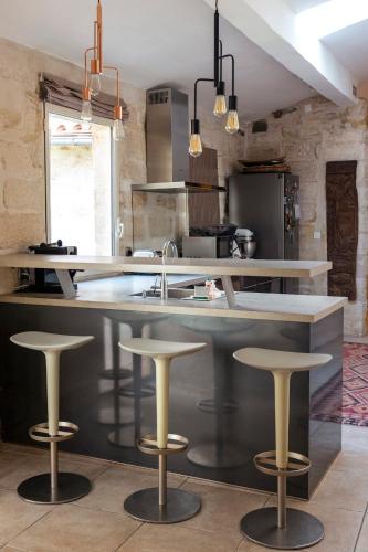 une cuisine avec un comptoir et des tabourets devant elle dans l'établissement Havre de paix à Villeneuve les Avignon, à Villeneuve-lès-Avignon