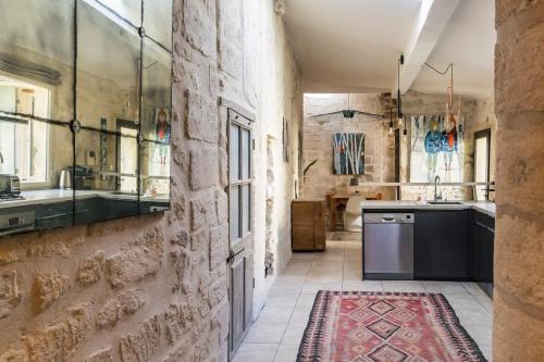 une grande cuisine avec un grand mur en pierre dans l'établissement Havre de paix à Villeneuve les Avignon, à Villeneuve-lès-Avignon