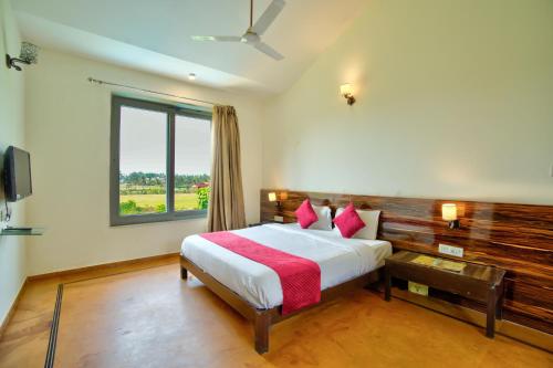 a bedroom with a large bed with a window at Luxury Aveeno Resort Near Calangute and Baga in Sangolda