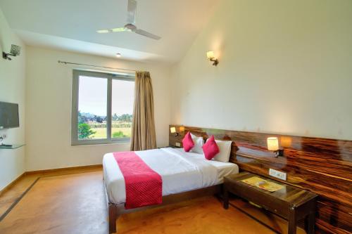 a hotel room with a bed and a window at Luxury Aveeno Resort Near Calangute and Baga in Sangolda
