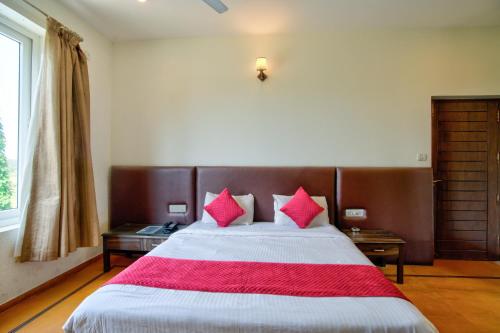 a bedroom with a large bed with pink pillows at Luxury Aveeno Resort Near Calangute and Baga in Sangolda