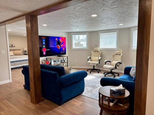 a living room with blue furniture and a flat screen tv at Bay Street Blue Ludington Park in Escanaba