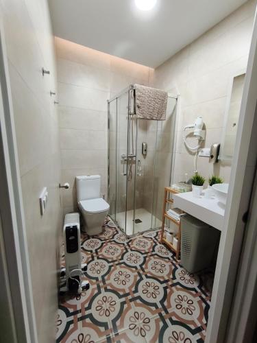 a bathroom with a shower and a toilet and a sink at AT Marem II in Cáceres