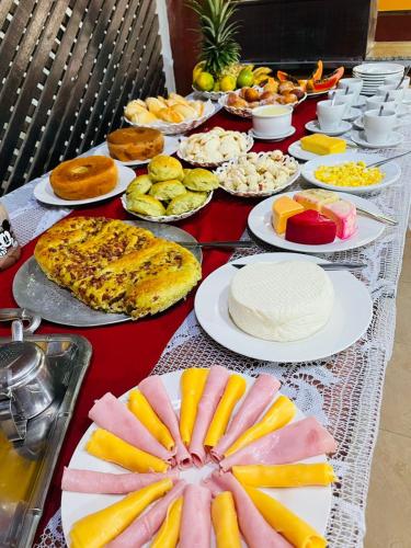 een lange tafel met veel borden eten erop bij Estância da vida Hotel e laser in Engenheiro Paulo de Frontin