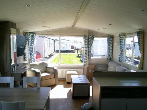 a living room with a couch and a table at Kingfisher Surf Shack 8 Berth Central Heated Close to site entrance FREE WIFI in Ingoldmells