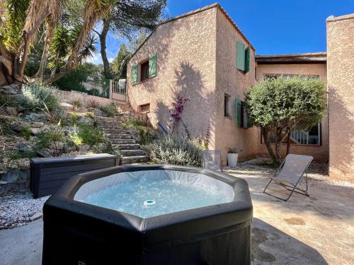 - un bain à remous dans une cour à côté d'un bâtiment dans l'établissement Superbe Villa vue mer - Jacuzzi - Pétanque, à Carqueiranne