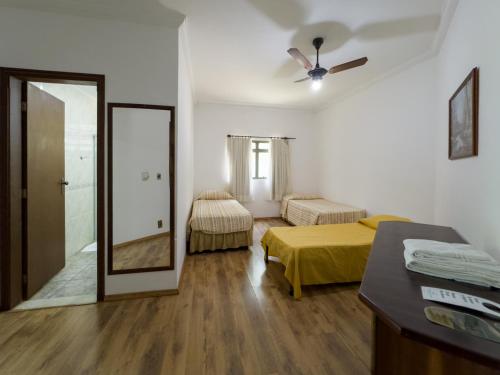 a hotel room with two beds and a mirror at Hotel Fazenda Fonte Colina Verde in São Pedro