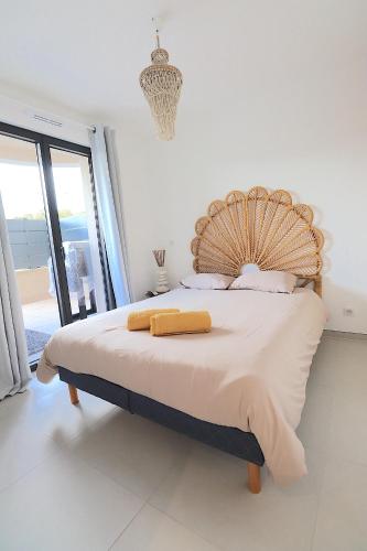 une chambre avec un grand lit avec une tête de lit en bois dans l'établissement Agosta Porticcio - Plage à 200m - T2 SUN entre mer & maquis - Barbecue- rés Fiore di maghja - PARKING - Wifi - 4 Pers, à Les Hameaux de Porticcio