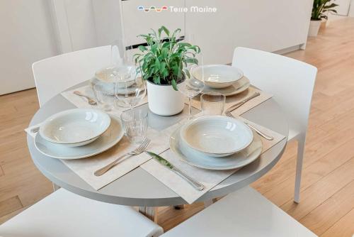 a white dining table with plates and glasses on it at Le Dimore dei Fiori, Terre Marine in La Spezia