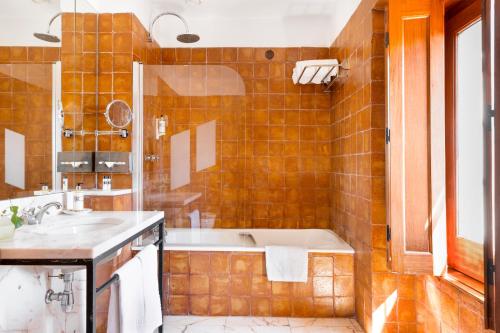 a bathroom with a tub and a sink at Pousada Convento de Vila Viçosa in Vila Viçosa