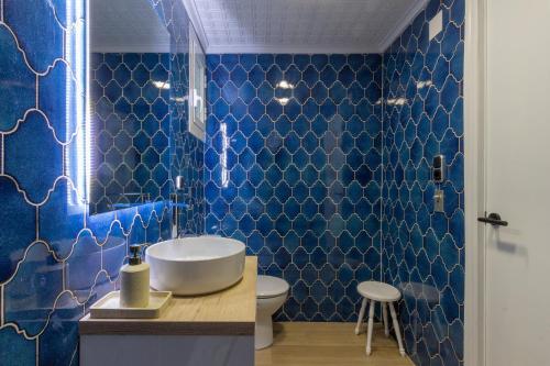 a blue tiled bathroom with a sink and a toilet at El Retiro de Julián in Santa Pola