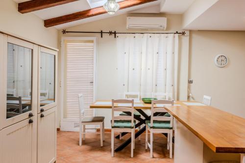 ein Esszimmer mit einem Holztisch und Stühlen in der Unterkunft Gran Hogar Alacant - Piscina y garaje in Gran Alacant