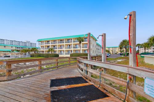 a wooden boardwalk with a building in the background at Plantation East 2205 in Gulf Shores
