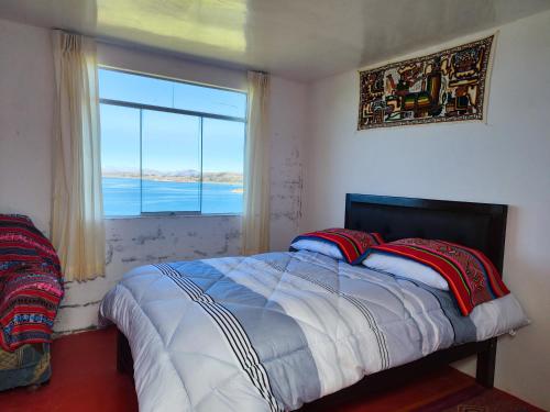 a bedroom with a bed and a large window at Titicaca Perka Lodge in Puno