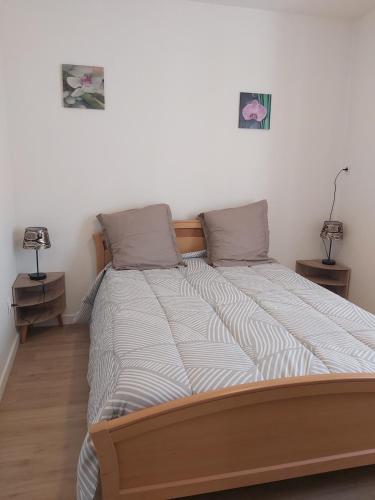 - un grand lit dans une chambre avec 2 tables de chevet dans l'établissement Appartement du Puits Barreau, à Marans