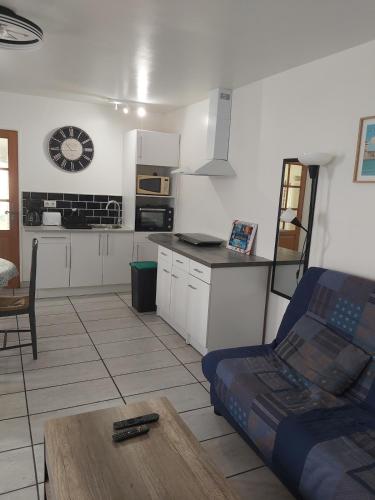 - une cuisine avec un canapé et une table dans une chambre dans l'établissement Appartement du Puits Barreau, à Marans