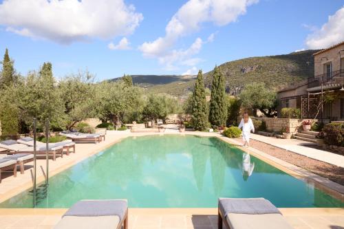 a woman is standing in front of a swimming pool at Liodentra in Kardamili