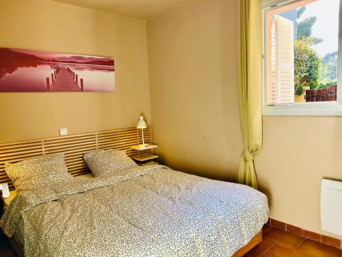 une chambre avec un lit et une fenêtre dans l'établissement Charmant et cosy T2 à deux pas du port dans un quartier calme, à Cavalaire-sur-Mer