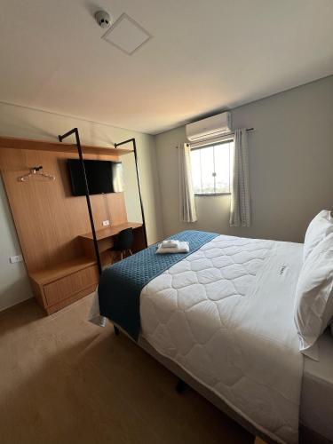 a bedroom with a large bed and a window at Barra Hotel in Vargem Grande do Sul