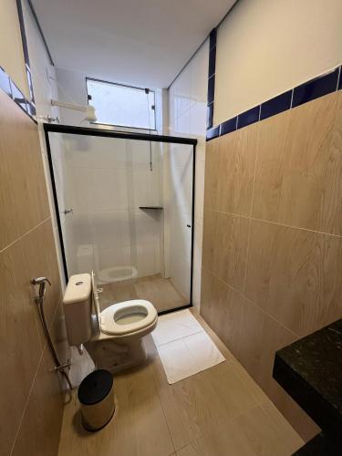 a bathroom with a toilet and a glass shower at Barra Hotel in Vargem Grande do Sul